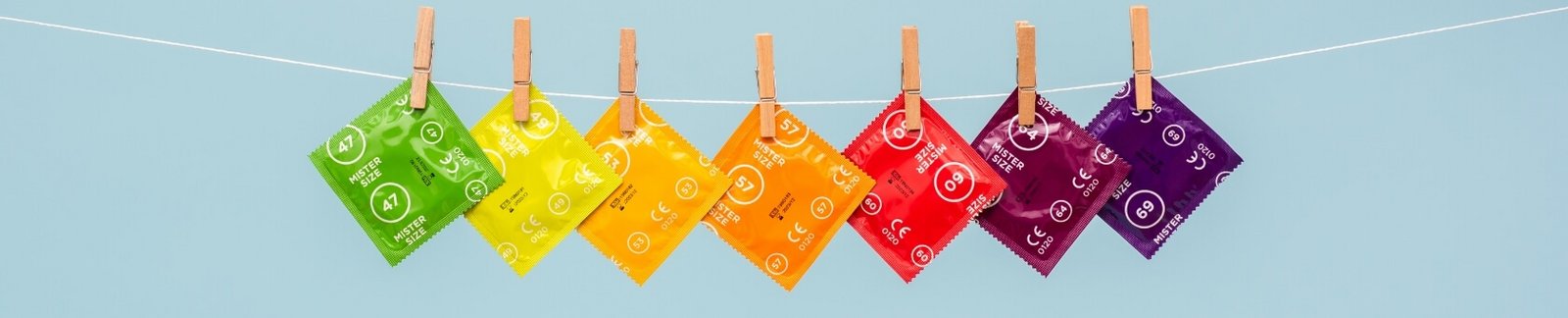 Preservativos Mister Size de diferentes tamanhos numa linha