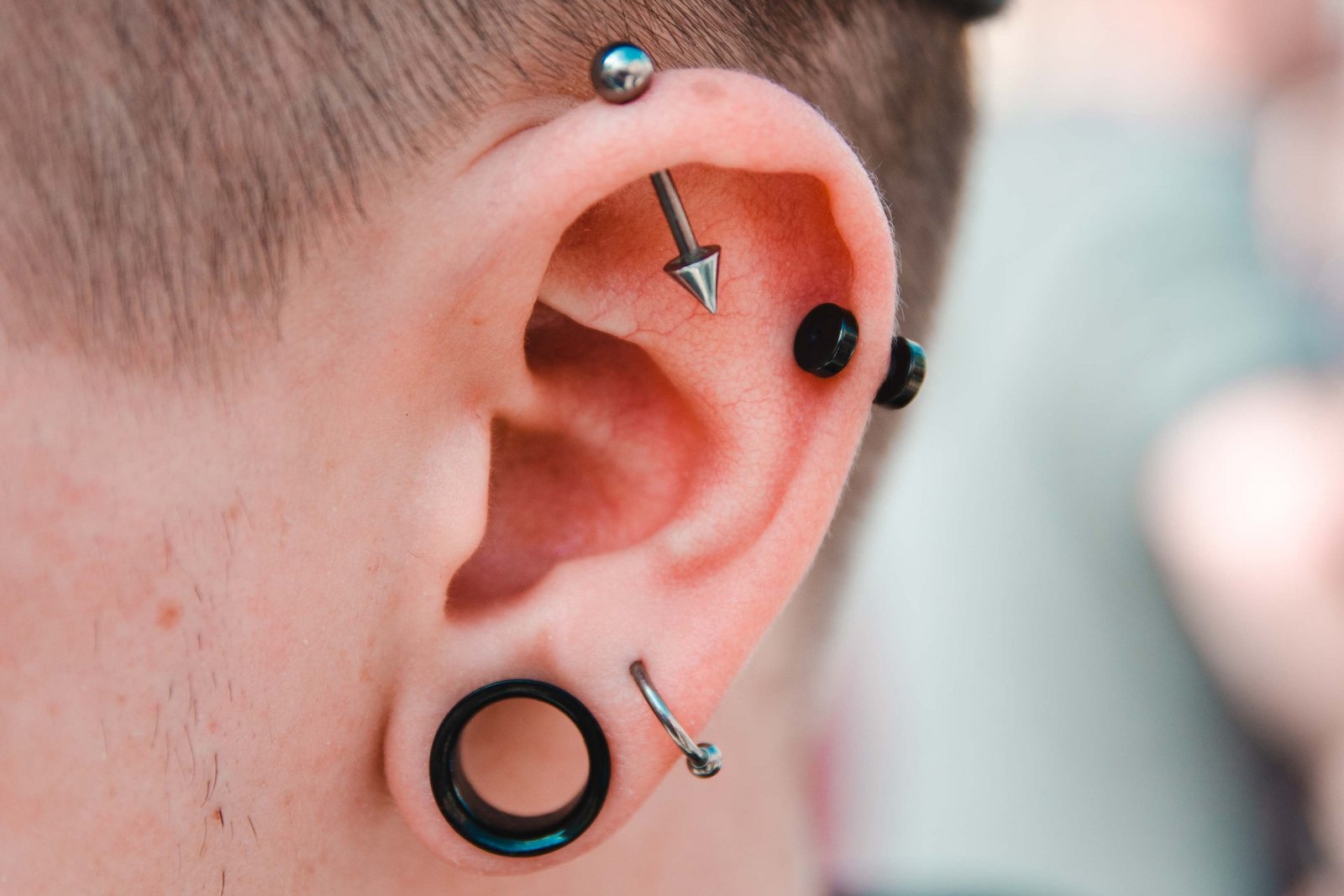 Homem com muitos piercings no ouvido