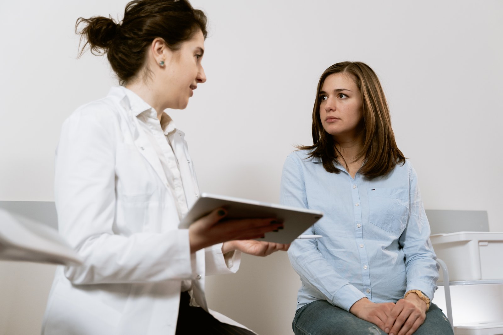 Uma mulher senta-se no ginecologista e fala com ela